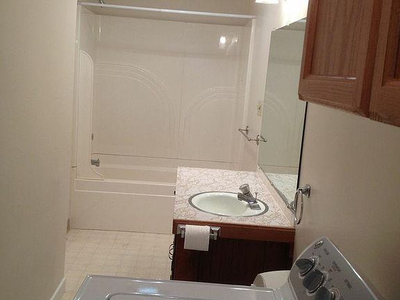 washer and dryer facing bathtub/shower
