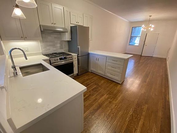 View back into living room from kitchen. New oven and refrigerator