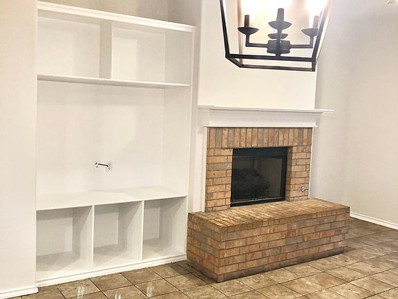 Open concept LR with gas-log fireplace and built in shelving