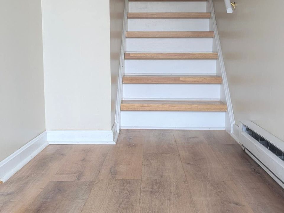 Stairs leading from the first floor (garage access through the door on the left) to the second-floor living room.