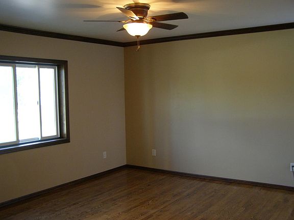Living room with ceiling fan & large slider window. The living room looks out onto the park across the street. Viewable Ice skating in the winter. The wall with window is now painted an accent color. The ceiling fan has been replaced from thatpictured.