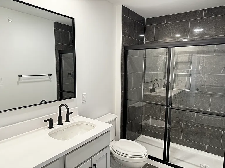 Master bathroom with contemporary design, bath area with sliding doors and large mirror