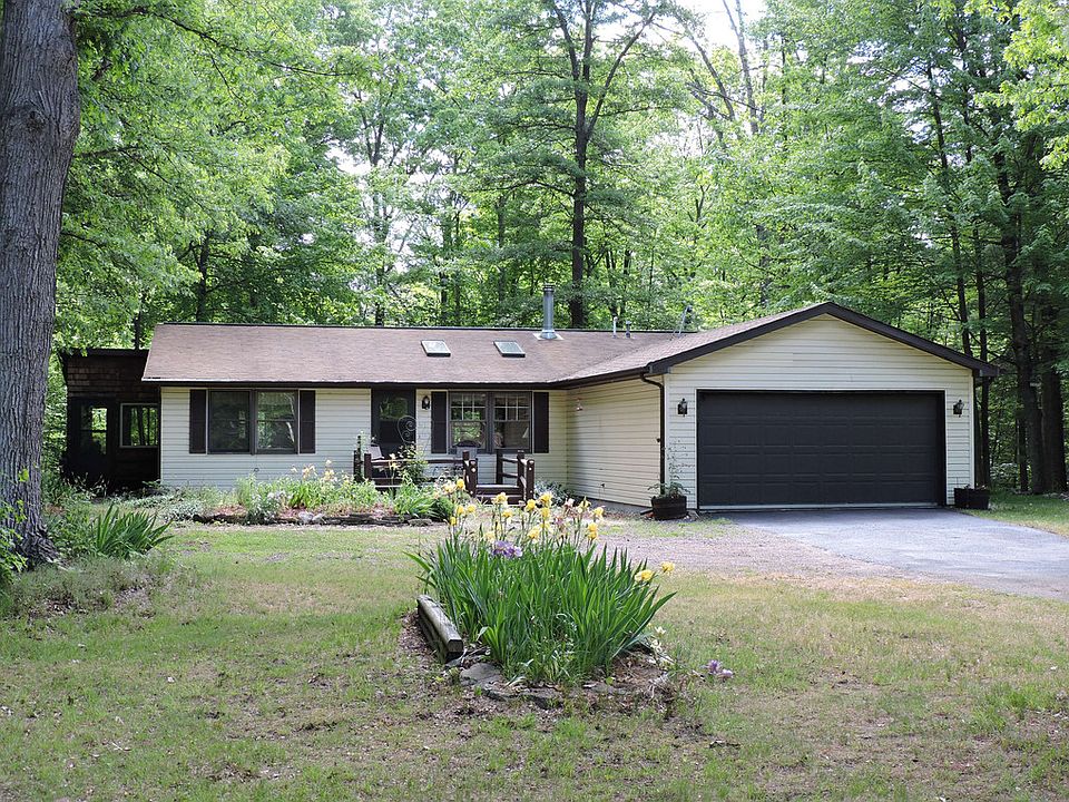 Shades of Summer...This beautiful 3 bedroom, 2 bath 2 x 6 constructed ranch sits on a shady 2.5 acre lot in the Sanford area. The sunlit living room features wood floors, vaulted ceilings, skylights, and a cozy wood stove. The privacy and stunning views of the wooded acreage atop a high ridge are offered from the 3-season room, dining room and kitchen.  Basement not included?  NO worries!  Use the 2nd level of the heated outbuilding for a rec room, craft area, or play room of any kind.  The main level of the outbuilding is great for storage or a workshop and includes a wood burning stove.  Although located in Coleman Schools, seller states the Meridian School Bus picks up students for school of choice.    