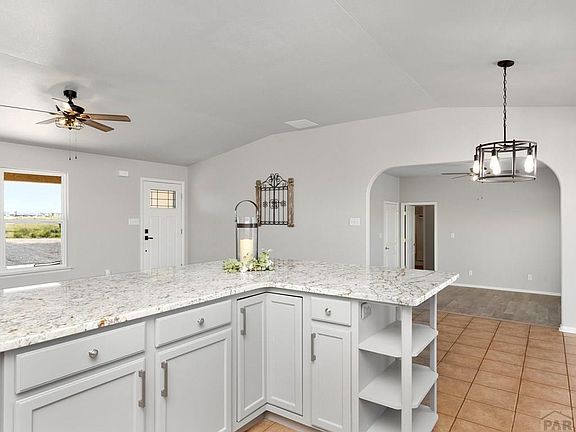 Kitchen, looking onto entry way and into additional living space