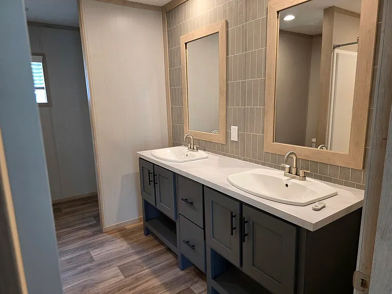 Master bath with dual sinks and storage. Includes a huge stand-up shower not pictured. Large additional storage partially pictured in back.