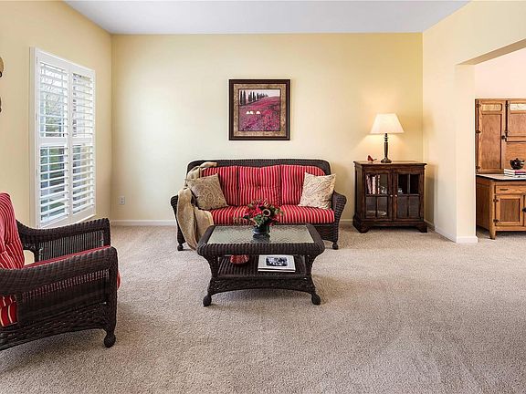 Formal living room features plantation shutters and opens to great room.