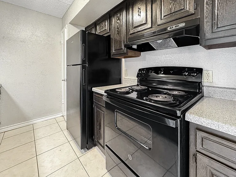 Efficient kitchen design with black appliances at Borders Apartments in Brownsville TX.