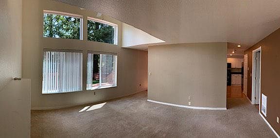 living room view facing backyard and deck. Laundry and 1/2 bath on right