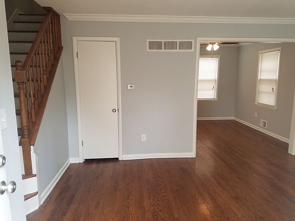 View from front door entry, looking into living room and dining room, coat closet and stairs.