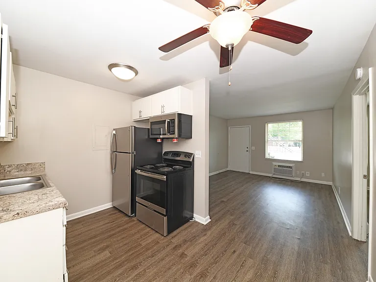 Kitchen area with stainless appliances and hardwood-style flooring