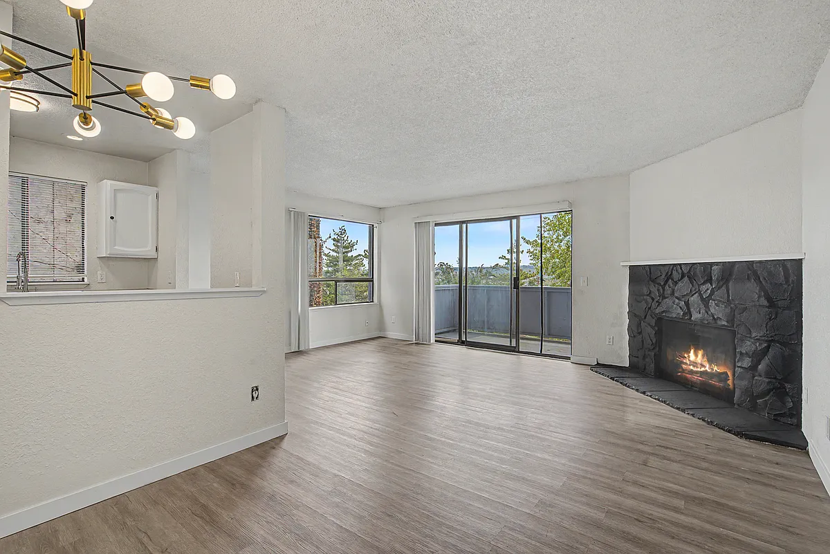 Warm and inviting living space featuring a cozy wood-burning fireplace, expansive sliding glass doors, and sweeping city views. - 530 Mill Ave S #2
