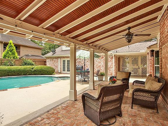 OUTDOOR LIVING: Doors from the family room open to the large covered patio with ceiling fan. It's not your ordinary patio. Notice the brick flooring, architectural columns and the wood beadboard ceiling.