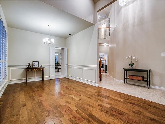 The hardwood floors extend into the formal dining area convenient to the kitchen beyond the double doors.