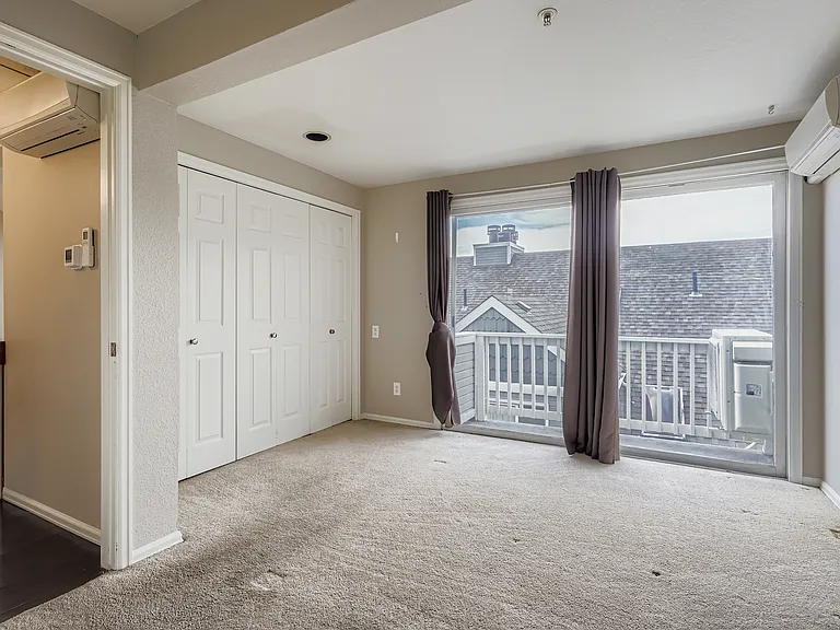 Primary bedroom (11.5 x 13.5) with private balcony. Faces south and receives a lot of light throughout the day. Large closet and split-unit AC/heater over bed area. New carpet installed since photo taken