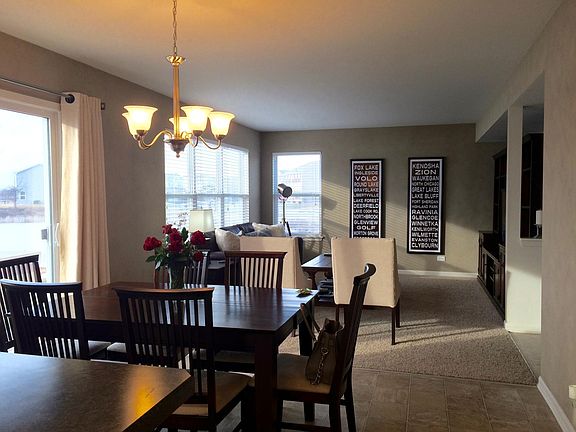 Combined family room, dining area, and kitchen with access to the patio.