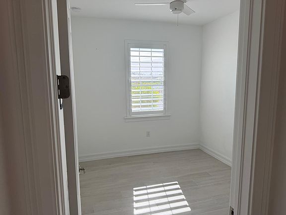 Guest Room featuring custom shutters that allow you to control the abundant natural light, beautiful sunrises, and a view of the lake.