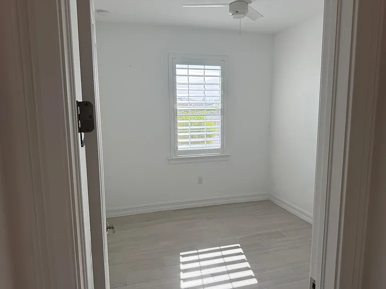 Guest Room featuring custom shutters that allow you to control the abundant natural light, beautiful sunrises, and a view of the lake.