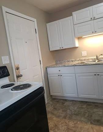 Kitchen, with back door between cabinets and stove