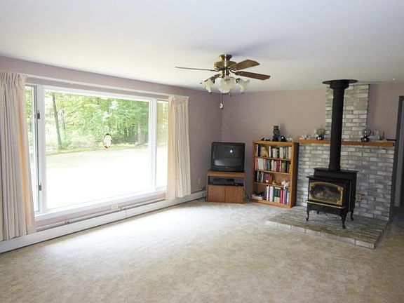 This lovely living room has a large picture window to look out onto those 2.29 acres.  The gas stove is a homey touch and provides some cozy warmth.