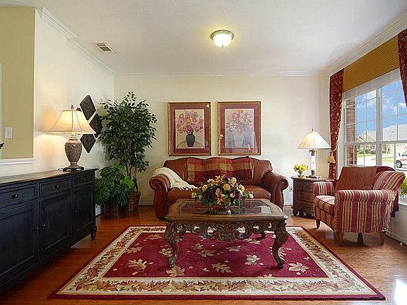 The Living Room offers rich wood floors, designer window treatment and crown molding