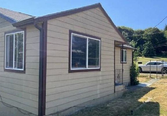 Front of house with large yard and off-street driveway