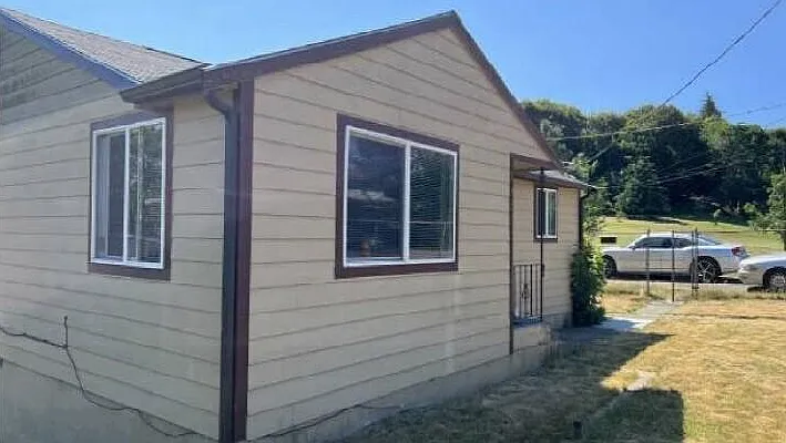 Front of house with large yard and off-street driveway