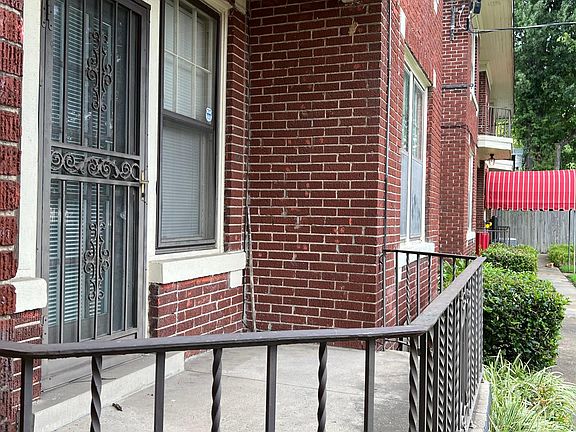 Gated patio on front of building with entry door into living room.