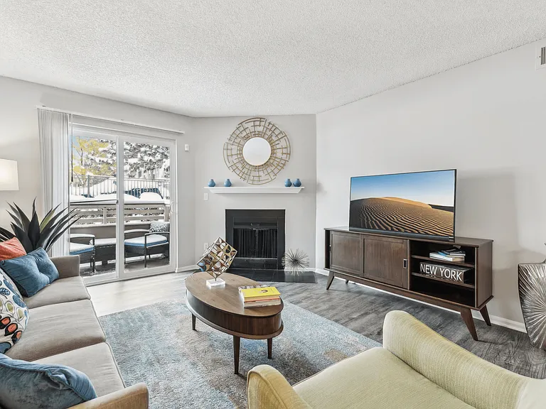 Open living room with seating and double doors for balcony access