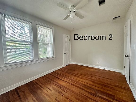 Cozy bedroom featuring real wood floors and a bright window that makes the space feel warm and welcoming.