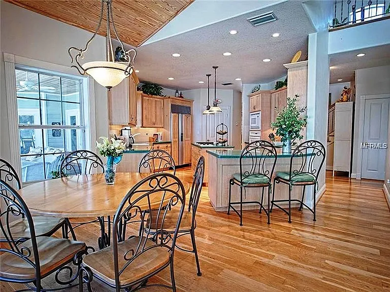 This is the breakfast nook off of the kitchen and next to the family room. It looks out on the main screened in porch overlooking the lake and the pool deck.