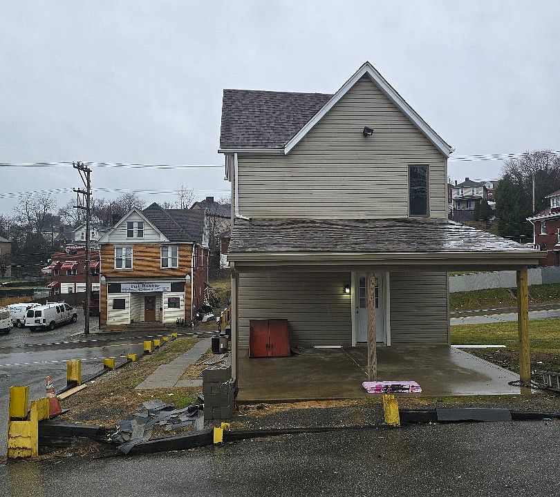 Back of house, covered patio and access to storm doors