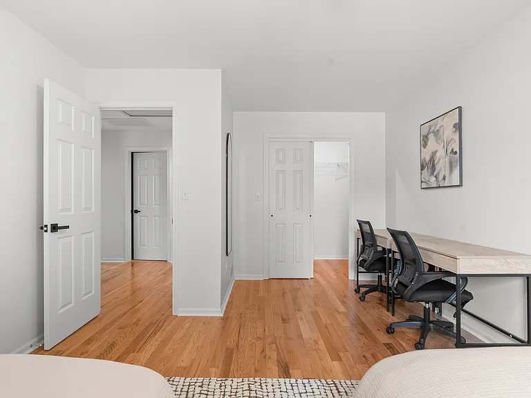 Upper-level bedroom with two full beds, two writing desks, and generous closet space.