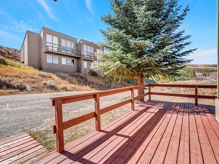 #207 is an end unit, with a wrap around front deck, small back storage shed, and parking area out front
