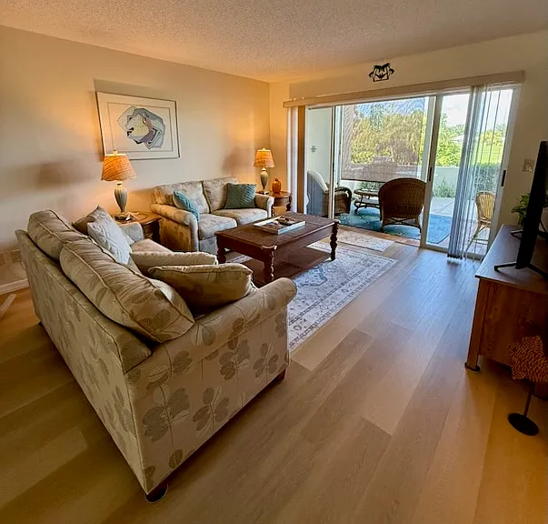 Living area with sliders to screened lanai and open patio