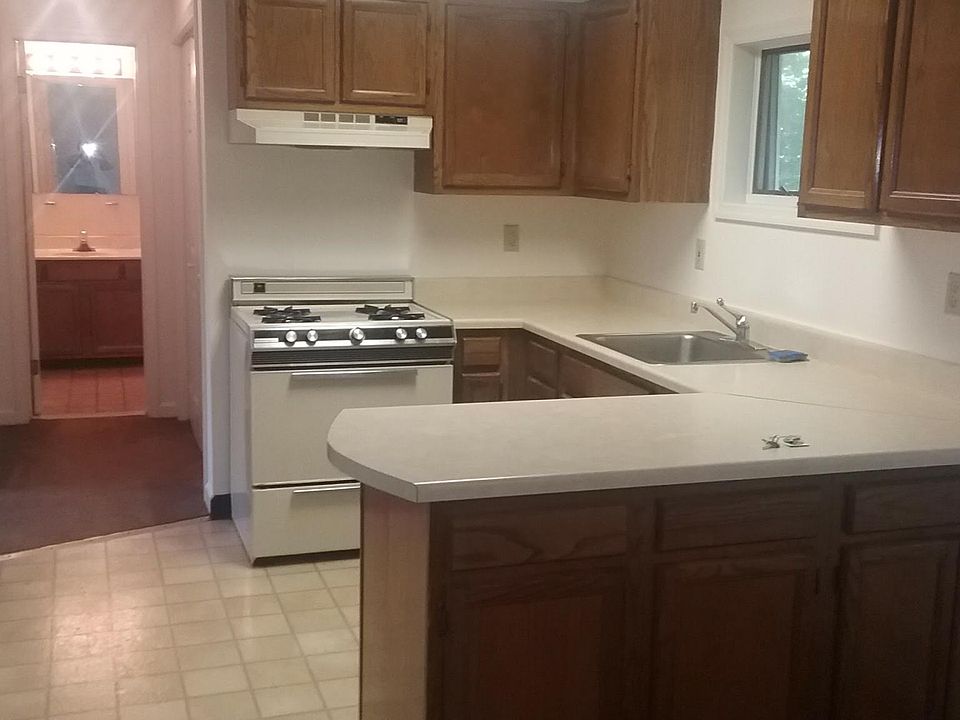 Kitchen looking into bathroom. Off the hallway, laundry room with washer dryer hookups on right and bedroom door left.
