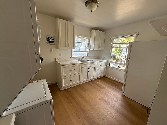 Newly Remodeled Kitchen ~ New cabinets, countertops, stove, flooring, in unit washer and dryer, full sized fridge, large windows.... cook a feast !