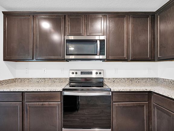 Gorgeous upper-wood cabinets with crown molding provide plenty of storage space