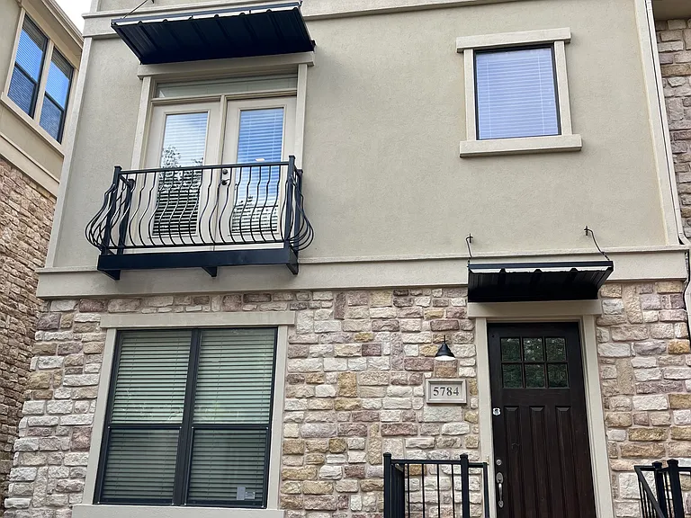 Wooden door entrance and ample front parking besides two car garage