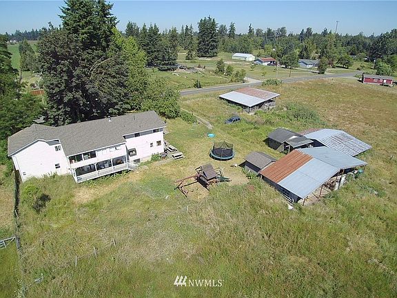 Overhead view of the main house which includes two 1BD/1BA apartments, the barns and the mobile with detached two-car garage in upper right corner.>