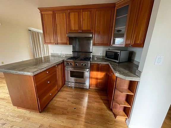 Kitchen with Blue Star Gas Range, Cherry Cabinets, Granite Counter tops, Ventahood, Microwave.