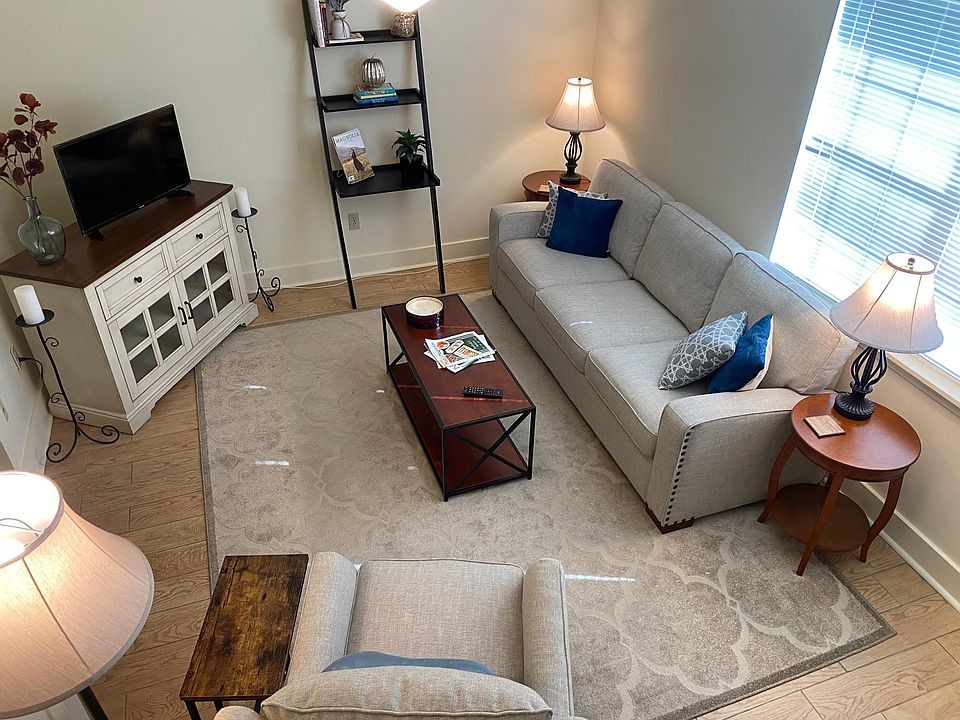 Spacious den/living room with ceiling fan and coat closet. (Plenty of natural night with two windows.