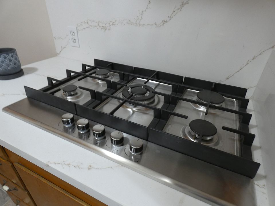 New high quality cook-top, gas with electric igniters. New counter top which is large on the bar and sink side of the kitchen. Built-in oven to the right of this photo.