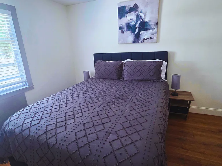Relax in a bright, cozy bedroom with premium linens and a plush queen bed.