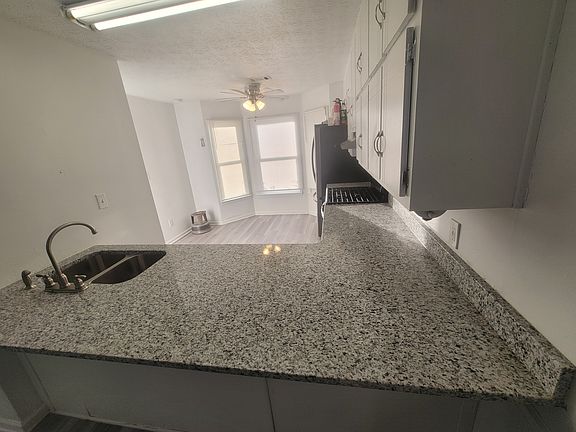 Plenty of room for a small dining table to nest in the beautiful bay window! The flow between the kitchen and living room creates a bright, inviting space designed for connection and comfort.