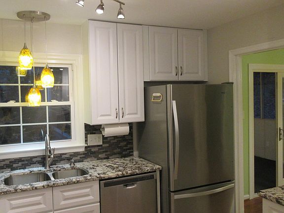 You'll love the new dishwasher and bottom-freezer refrigerator! Kitchen opens into cheery green dining room, and adjoining screened porch overlooks the back yard.