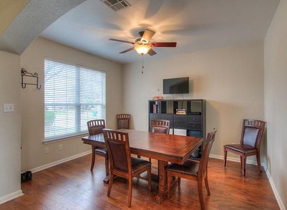 Formal dining room on the left as you enter the home.  Notice the hand scraped wood floors and  ceiling fan.