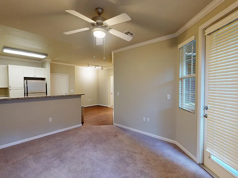 Apartment living room with carpet floor and balcony.