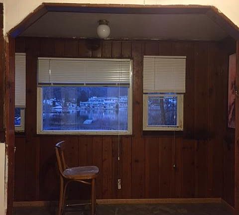 New carpet in living room with nook and view of lake and doc