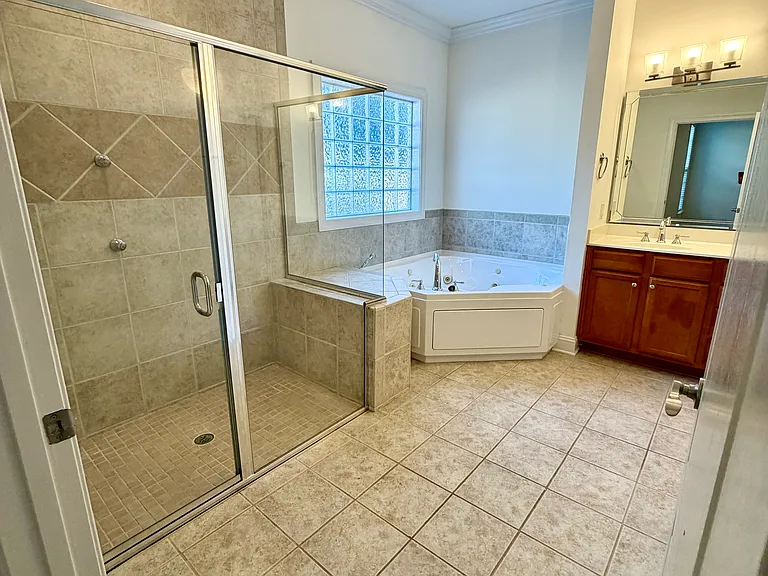 Spacious primary bathroom with large walk-in shower, garden tub, dual vanities and separate water closet for added privacy and ample storage space