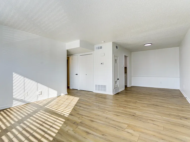 A bright living room with vinyl floor is shown at ReNew on Cantrell.